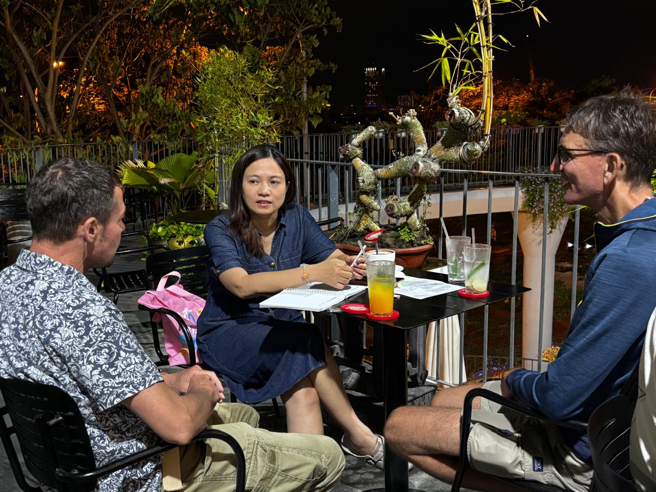 Members practicing together at a table with notebooks and drinks during the Friday, April 24, 2026 Da Nang Language Exchange session.